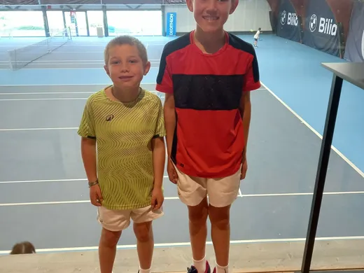 Deux jeunes joueurs sur un court couvert