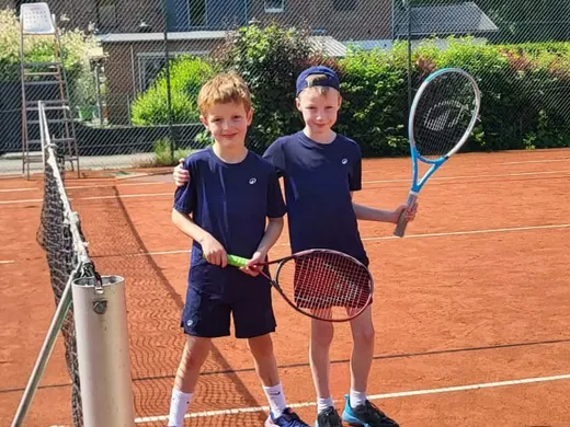 Deux jeunes joueurs sur un court extérieur